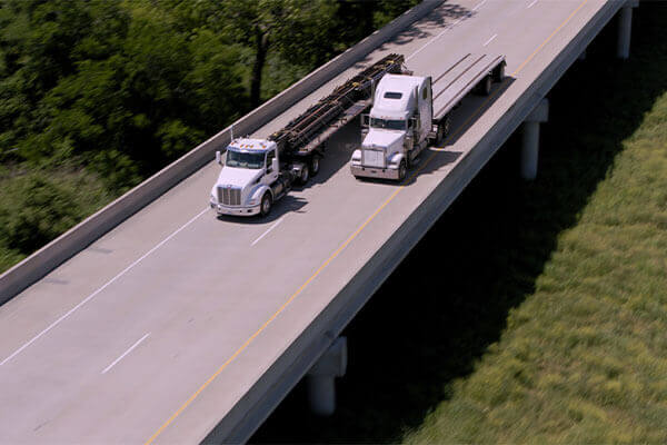 Aerial view of two large trucks driving on SH 130