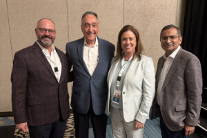 Four professionals posing together at a chamber of commerce conference event.