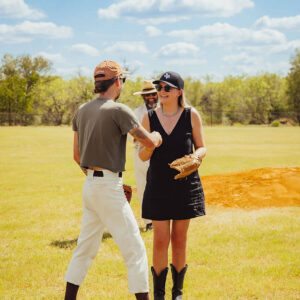 Two people greeting each other on a baseball field at Wishing Well Field in Lockhart during a community event.