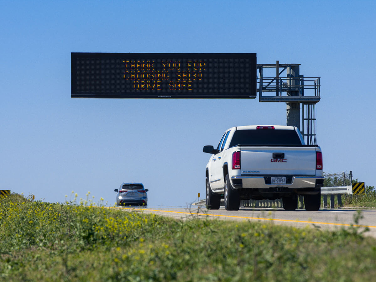 Vehicles traveling on SH 130 beneath an electronic highway sign reading "Thank You for Choosing SH130 – Drive Safe."